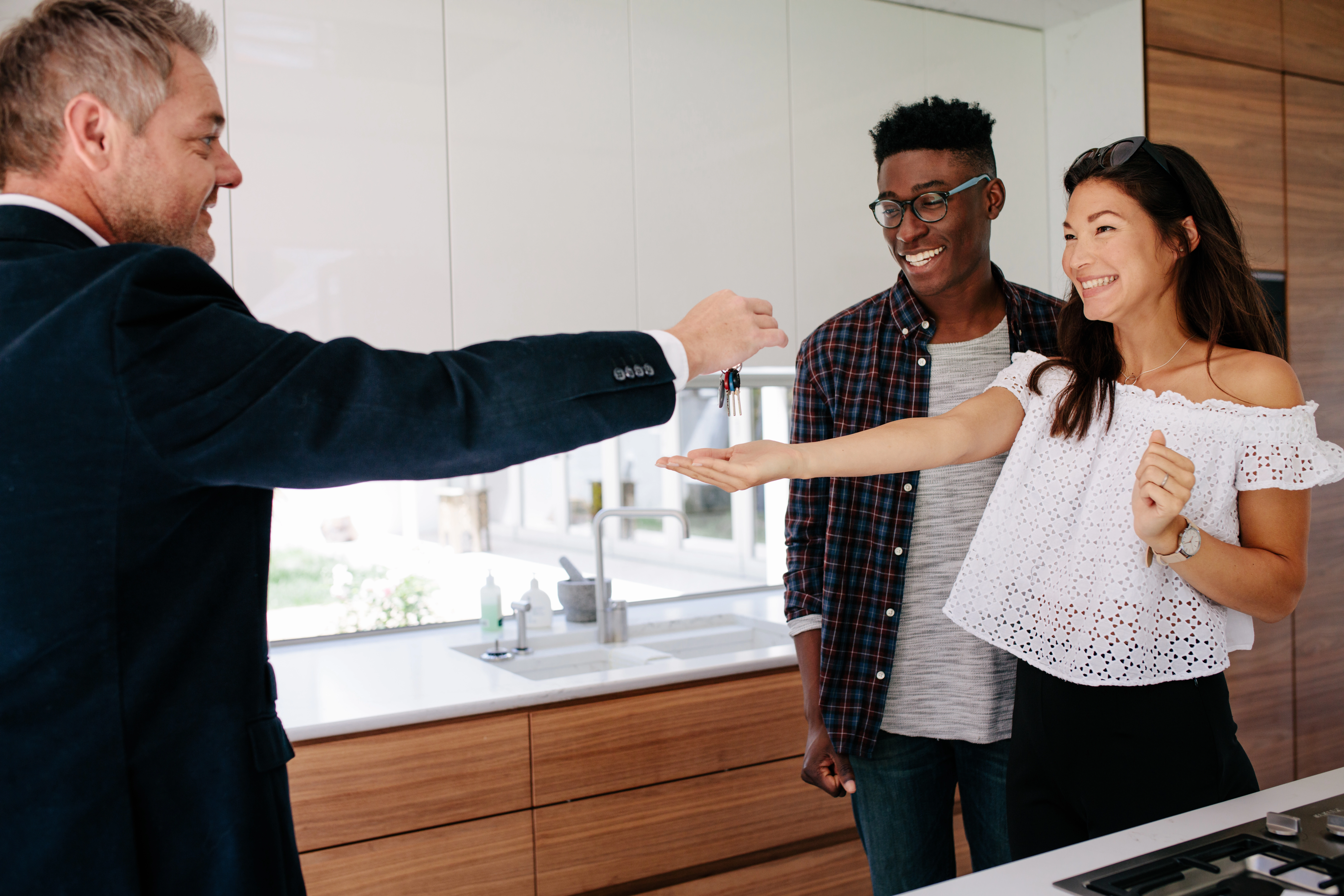 Real estate agent handing keys to happy homeowners